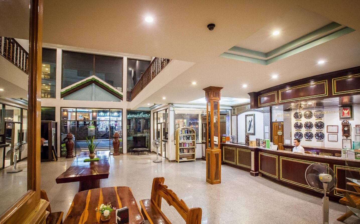A spacious lobby with a reception desk, a coffee bar, and a seating area with wooden furniture.