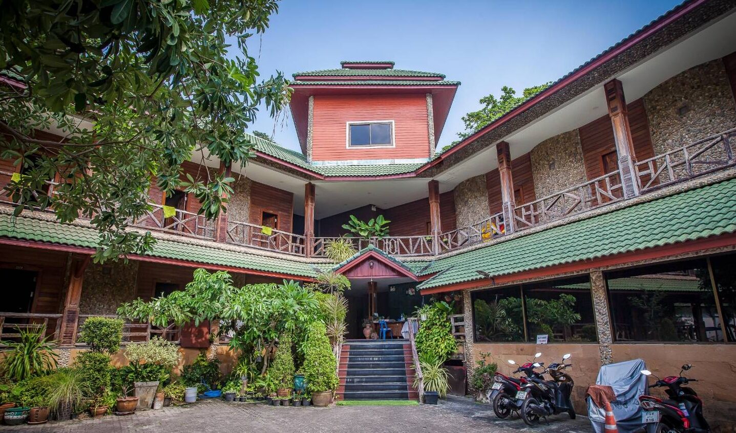 A traditional building with a central tower, multiple balconies, and a covered entrance.