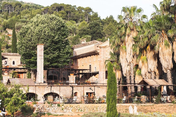 A stone building with a balcony and outdoor seating area. - Hotel Finca Ca N'ai - Bio Nature Adults Only (Sóller)