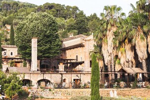 A stone building with a balcony and outdoor seating area.