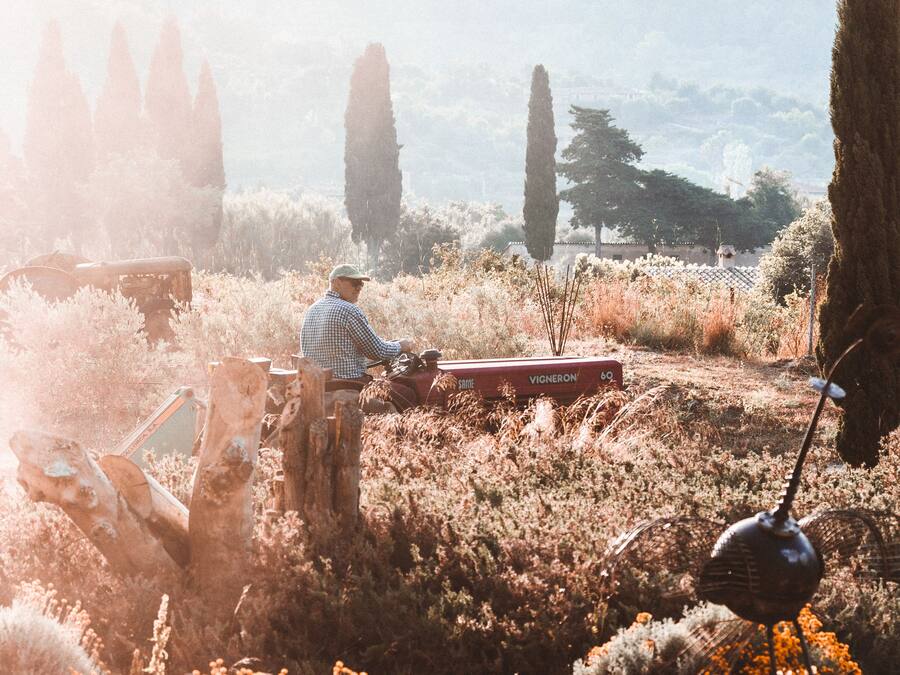 Una persona trabajando en un campo con un tractor y una radio antigua.