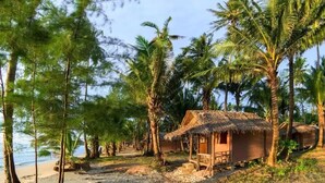 A beachside resort with thatched-roof huts, palm trees, and a sandy beach. - Koh Chang Thai Garden Hill Resort (Ko Chang)