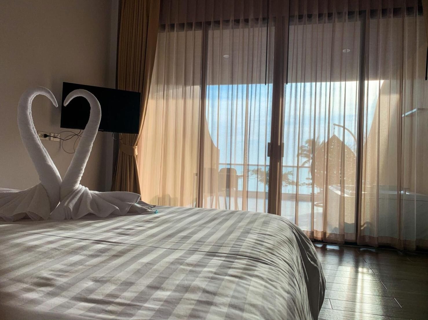 Een hotelkamer met een bed, een televisie en uitzicht op de omgeving.