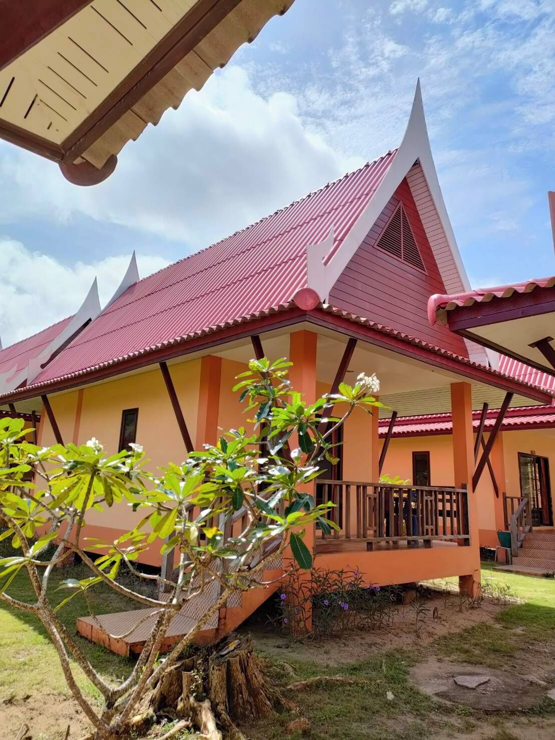 A traditional building with a red roof and a porch.