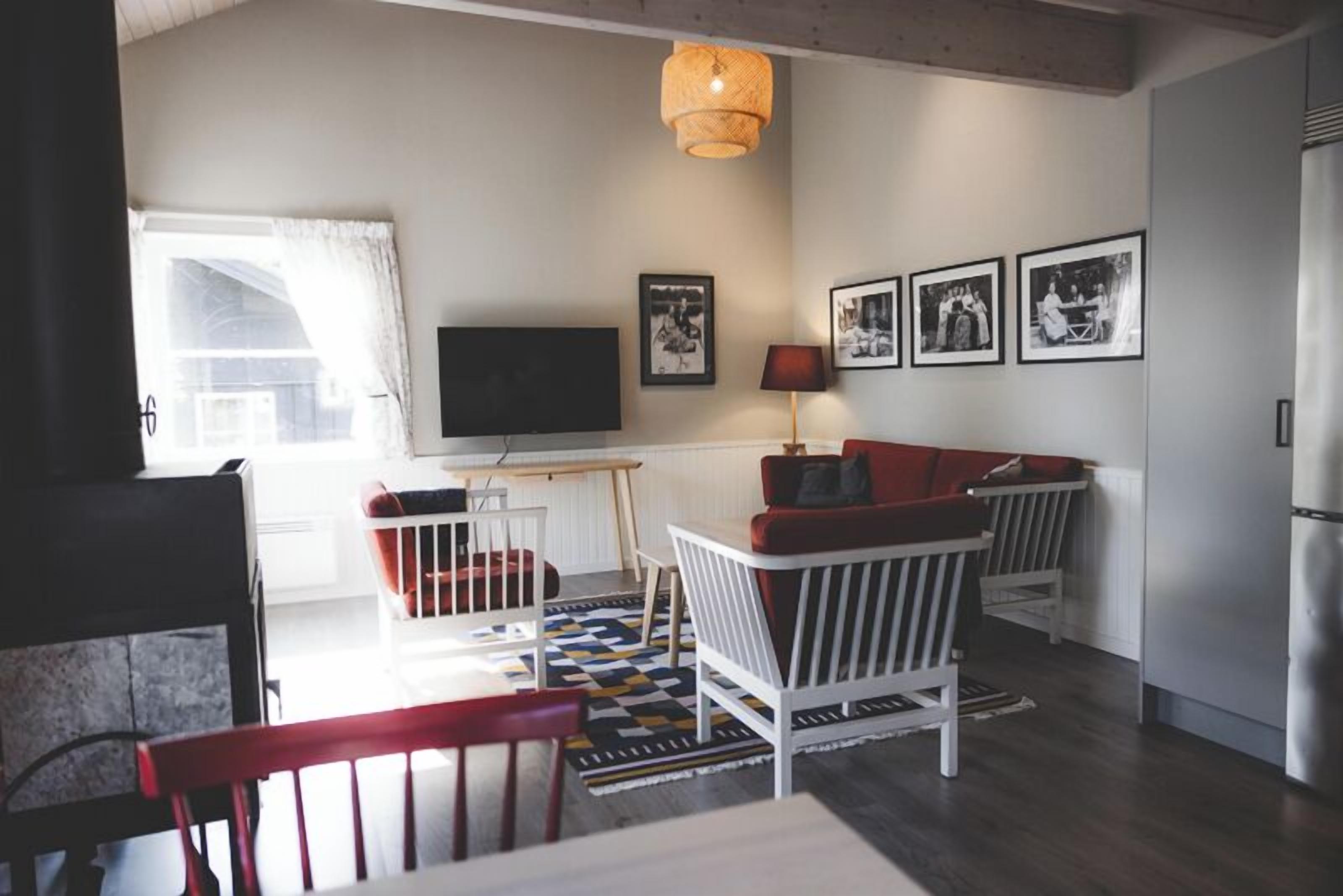A living room with a television, a sofa, a table, and a chair.
