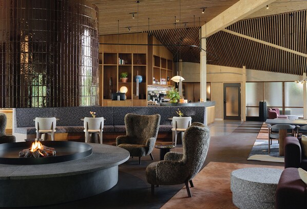 Un vestíbulo moderno con una zona de estar central, un bar y una recepción.