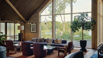 A spacious living room with a large window, a sofa set, and a coffee table.