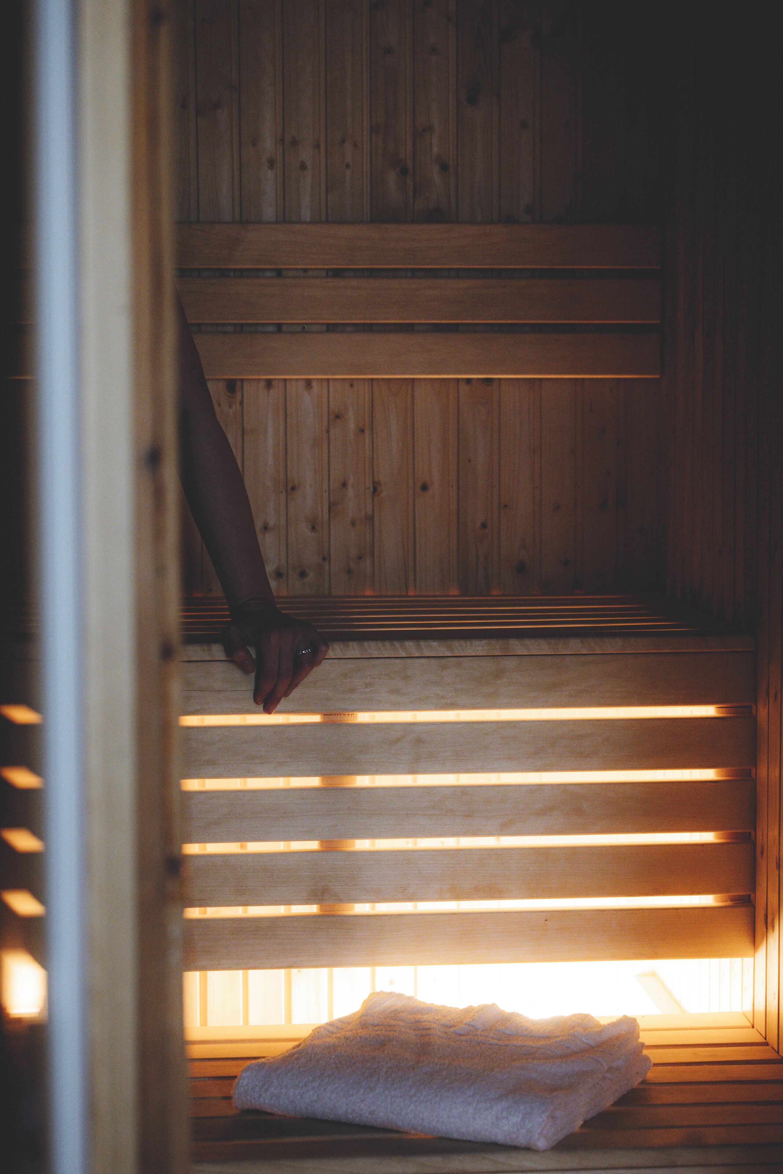 Una sauna de madera con bancos y una toalla en el suelo.