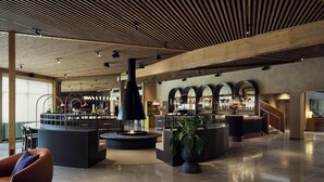 A spacious lobby with a central seating area, a bar with arched windows, and a modern ceiling design. - Marholmen Stugor (Norrtälje)