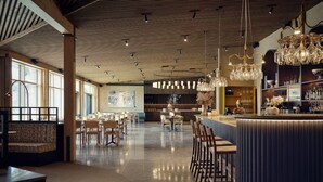 A modern restaurant with a bar area, wooden ceiling, and large windows. - Marholmen Stugor (Norrtälje)