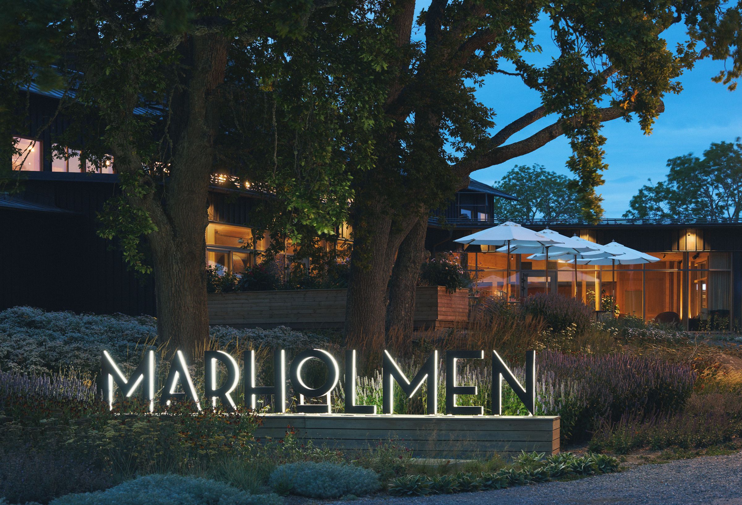 En modern byggnad med en stor, upplyst skylt som visar texten ”MARILMEN”.