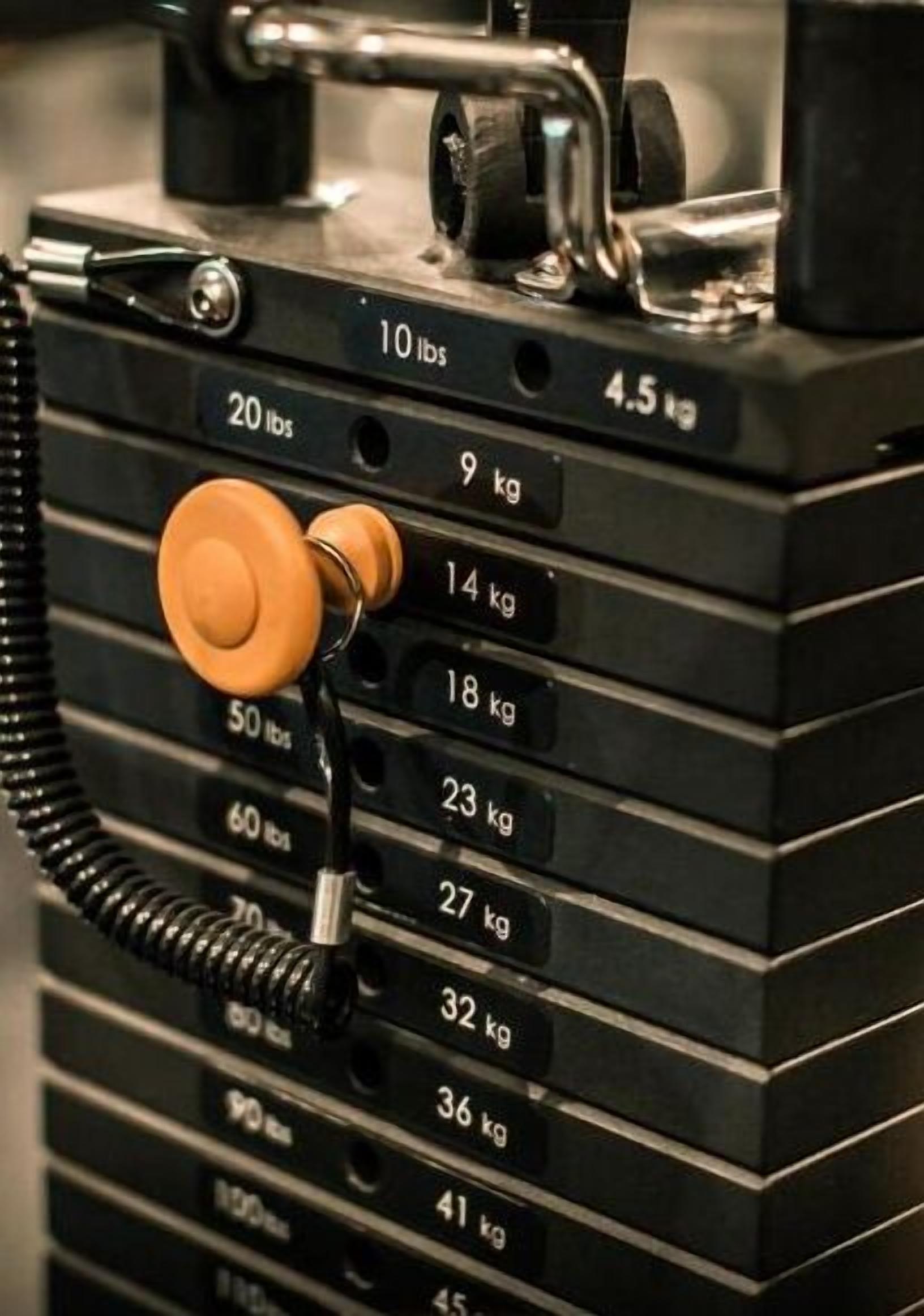 A stack of black weight plates with visible weight markings ranging from 4.5 kg to 41 kg.