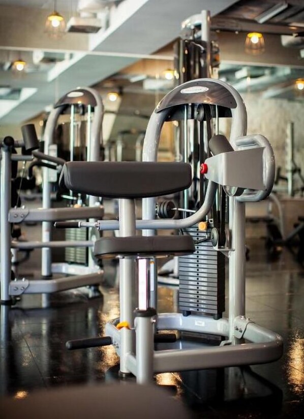 A row of stationary exercise machines in a gym with a modern design and reflective flooring. - White Sand Princess Hotel (Ko Chang)