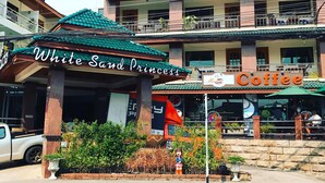 A building with a sign for "White Sand Princess" and a coffee shop.