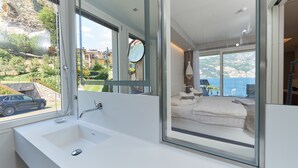 Un baño moderno con un ventanal grande, un lavabo blanco y un espejo.