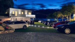 Un hotel moderno con un letrero que dice "JL LIVING SUITE" frente a un estacionamiento con varios autos.