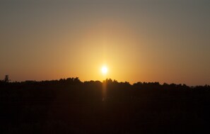 A sunset over a silhouette of a forested area. - Axos Apartments (Hersonissos)