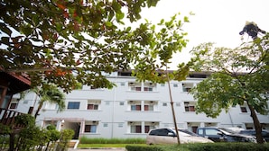 Un immeuble résidentiel à plusieurs étages avec un espace de stationnement à l’avant.