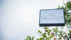 Une enseigne pour « The Habitat Hostel Koh Chang », au design simple et au texte clair.