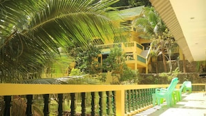 A yellow building with balconies and a covered walkway. - Island Lodge (Ko Chang)