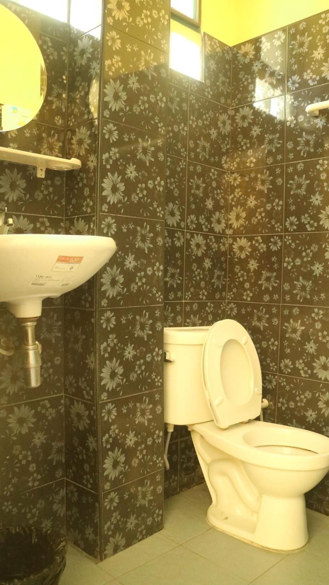 A bathroom with a toilet, sink, and mirror.
