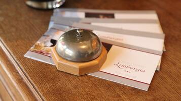 A wooden table with a metal object on top, a brochure, and a glass of water.