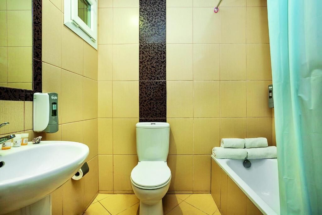 A bathroom with a toilet, sink, and bathtub.
