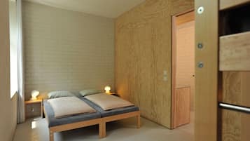 Une chambre à coucher moderne avec un lit, des lampes de chevet et une armoire en bois.