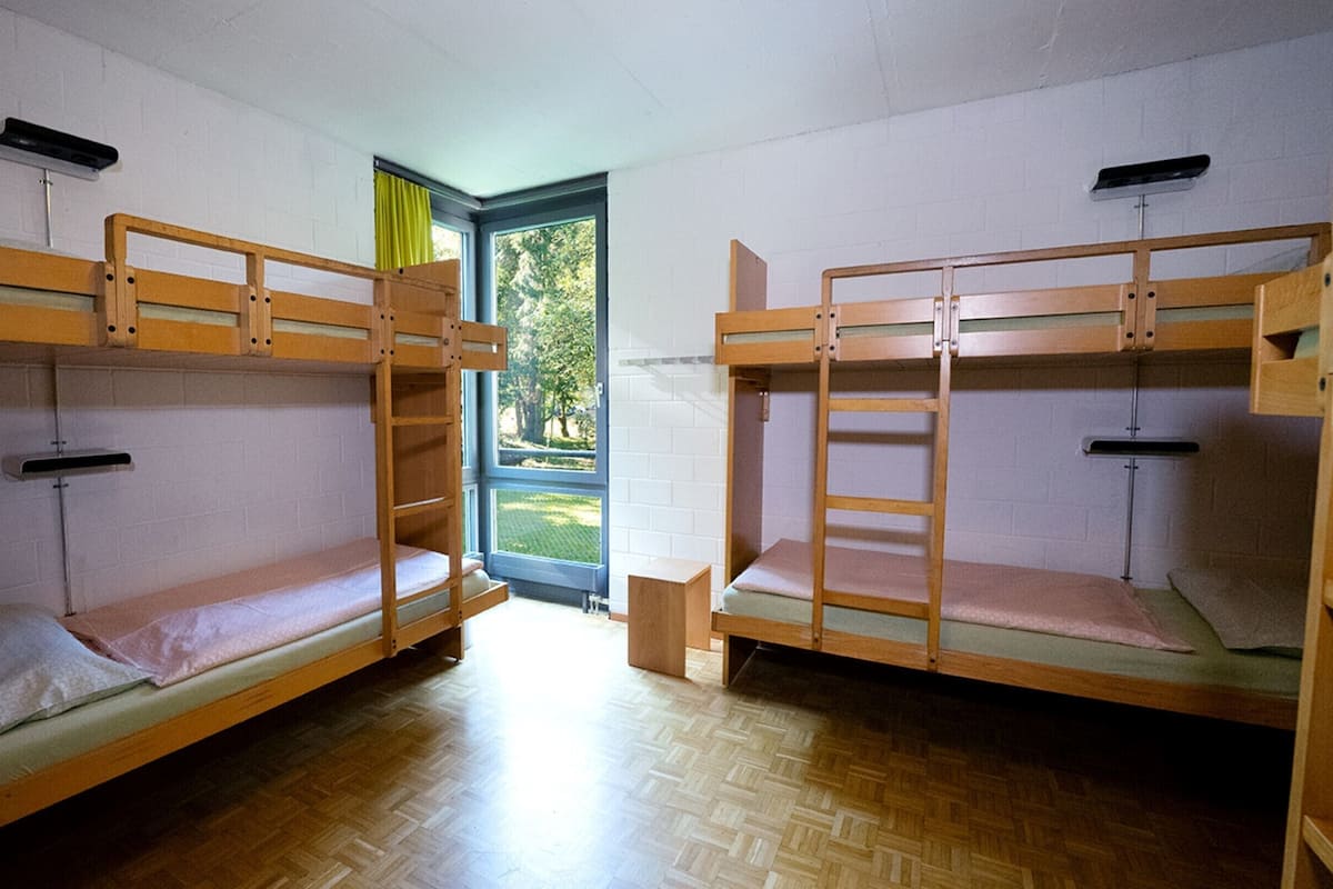 Un dormitorio con literas, una ventana y una puerta.