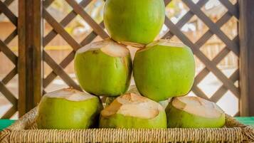 Un montón de cocos verdes en una cesta tejida.