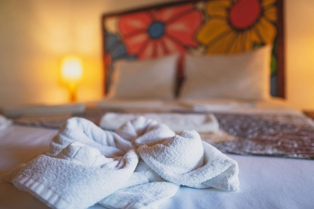 Une chambre d’hôtel avec un lit, une table de chevet et une lampe.