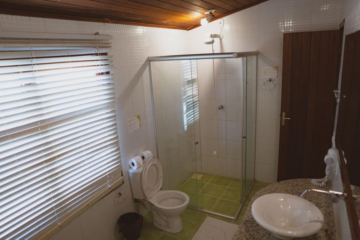 Une salle de bain avec des toilettes, une douche et un lavabo.