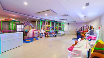 Zona de juegos infantiles con estructuras coloridas y un mostrador de recepción.