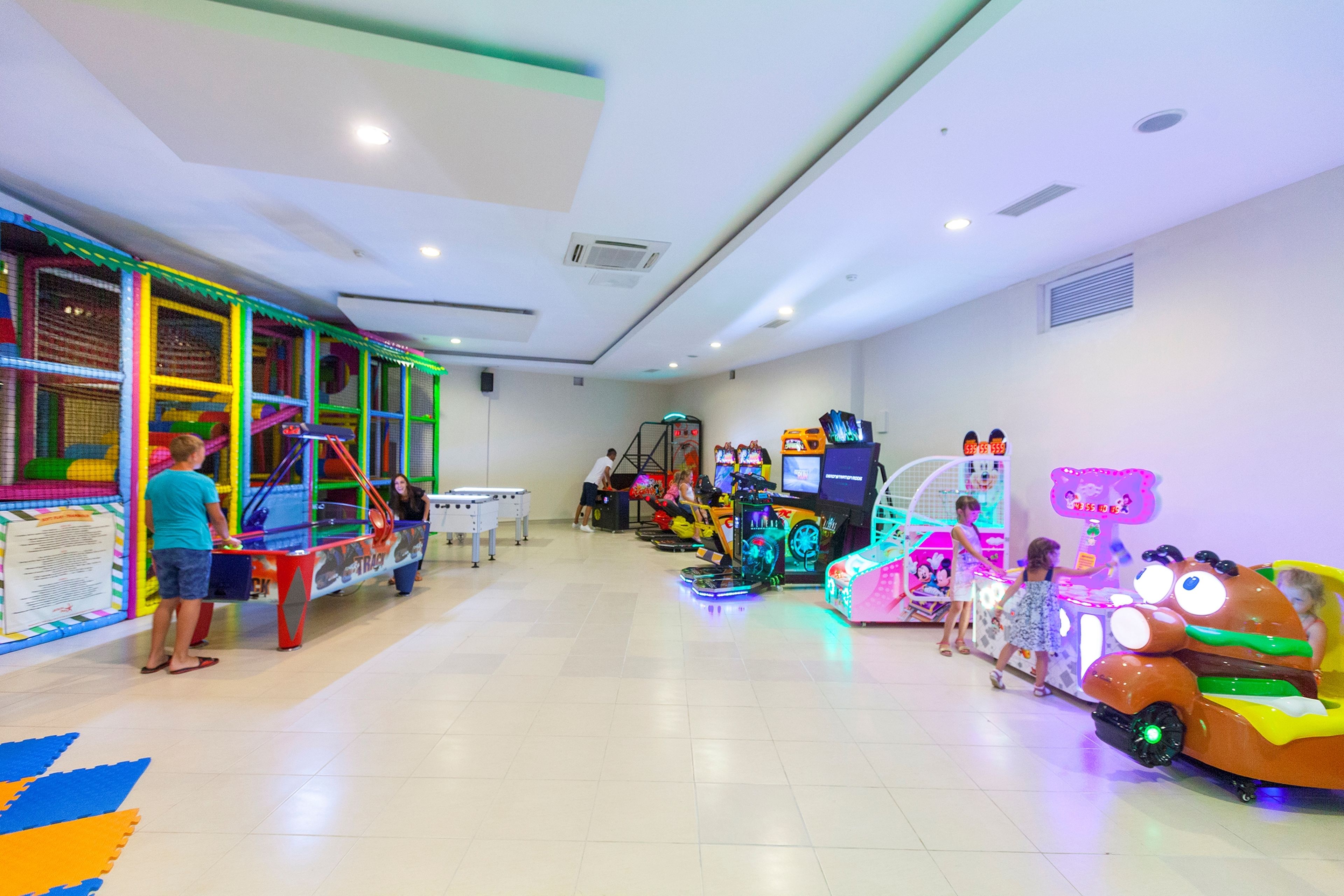 Un espacio de juegos interior con diversos juegos y actividades para niños.