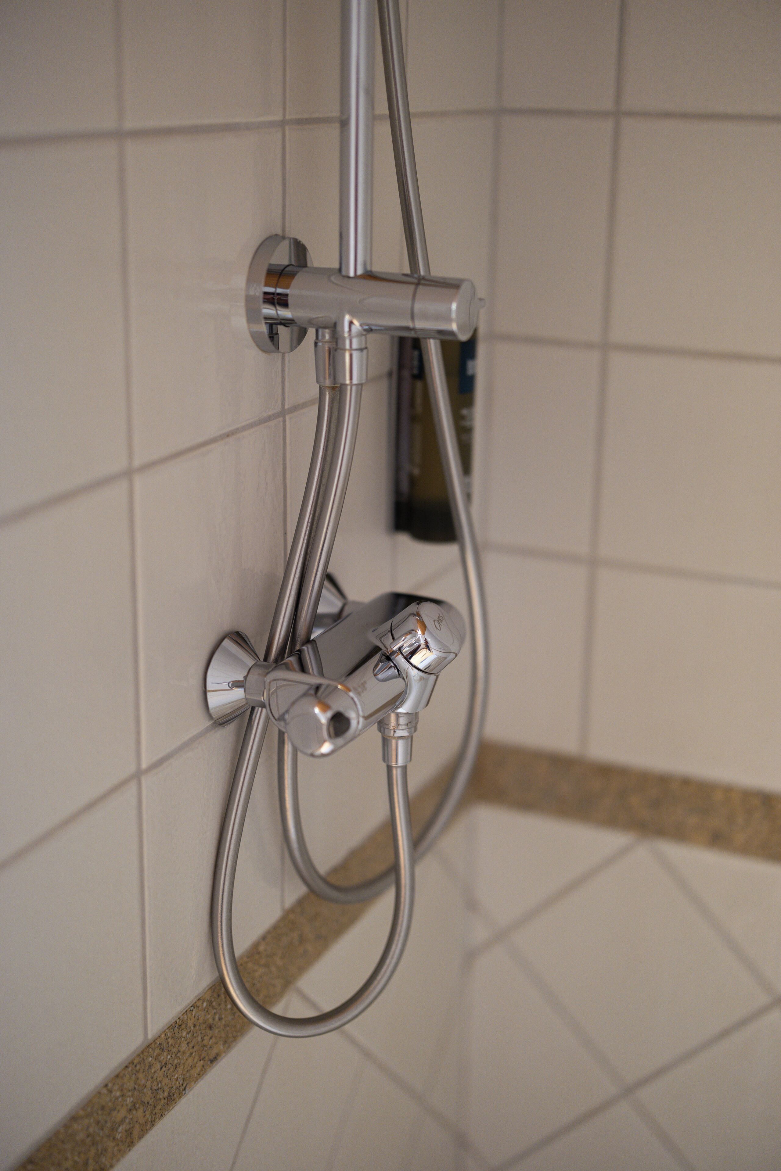 Una ducha con cabezal de ducha manual y grifo empotrado.