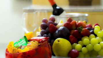 Uma tigela com frutas variadas e um recipiente vermelho com balas.