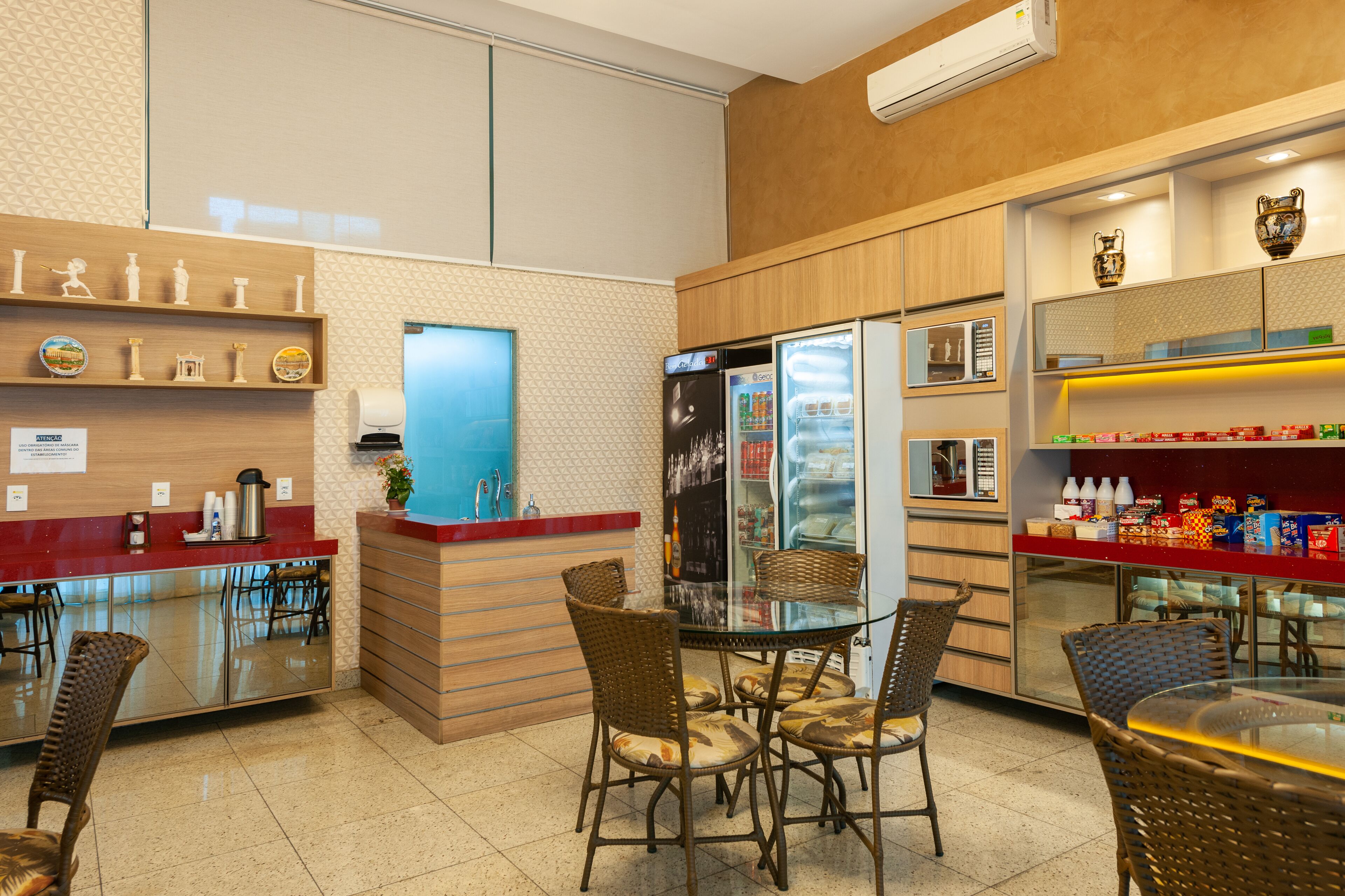 Un restaurante con mostrador, zona de mesas y un refrigerador.
