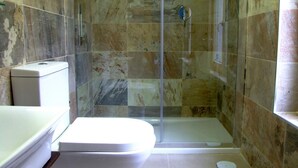 A bathroom with a glass-enclosed shower, a toilet, and a bathtub. - Hostal Vintage Santander (Santander)