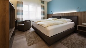 A modern hotel room with a large bed, a desk, and a chair. - Hotel Nagel (Sudlohn)