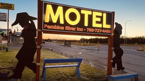 Señal de motel con el nombre 'Motel' y un número de teléfono.