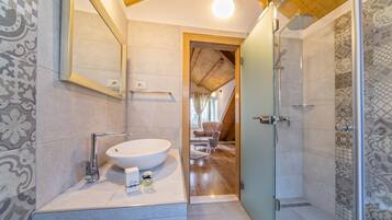 Un baño moderno con un lavamanos grande, un espejo y una zona de ducha.