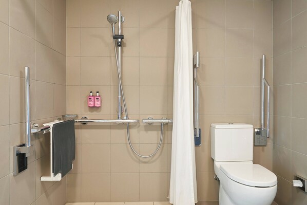 A modern bathroom with a shower, toilet, and towel rack.