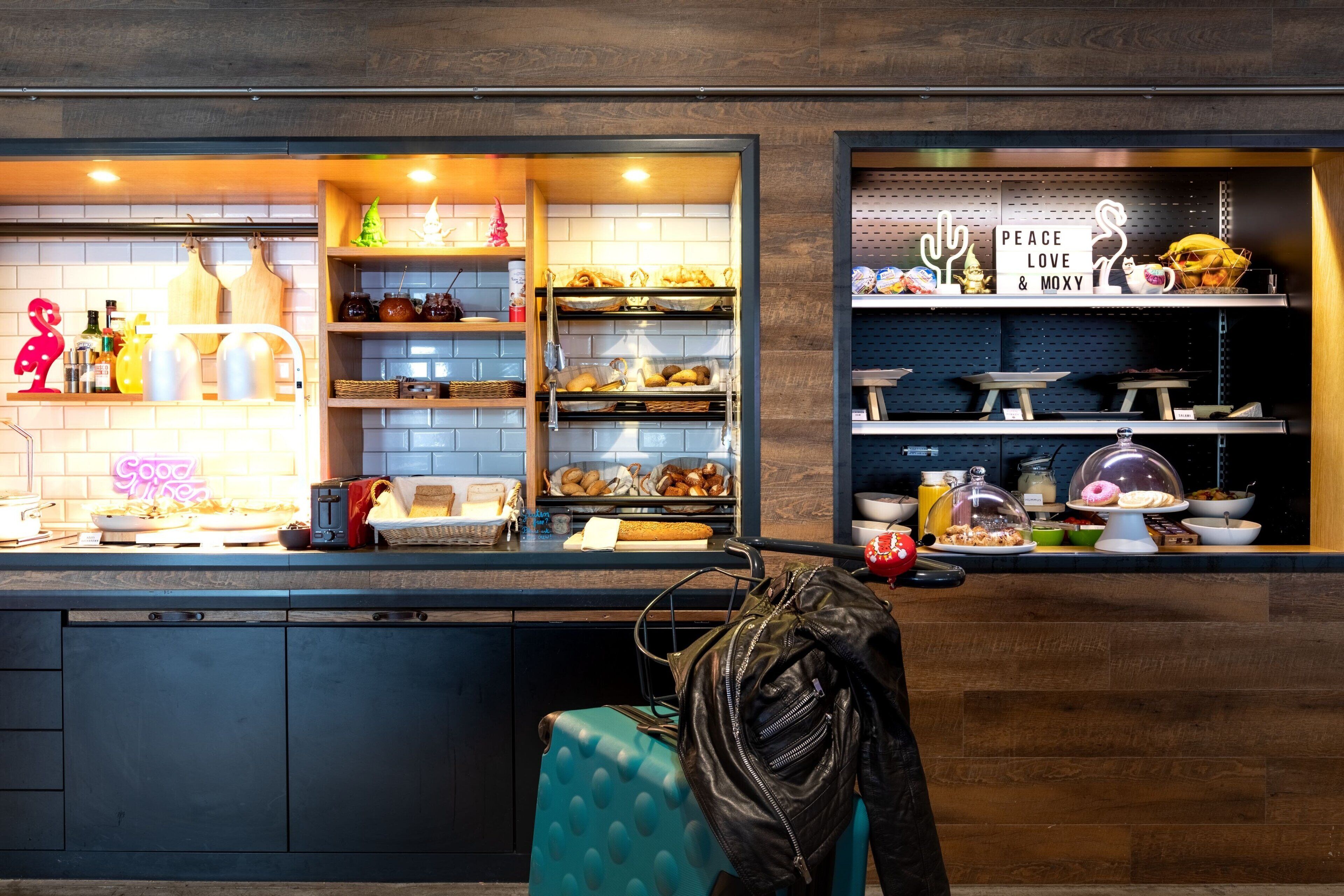 A bakery counter with various baked goods and a sign that reads "PEACE LOVE & MOXY".