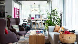 Una sala de estar moderna con un sofá, un sillón, una mesa de centro y un escritorio con una computadora.