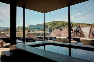 Uma área de piscina interna moderna com vista para uma cidade e colinas.
