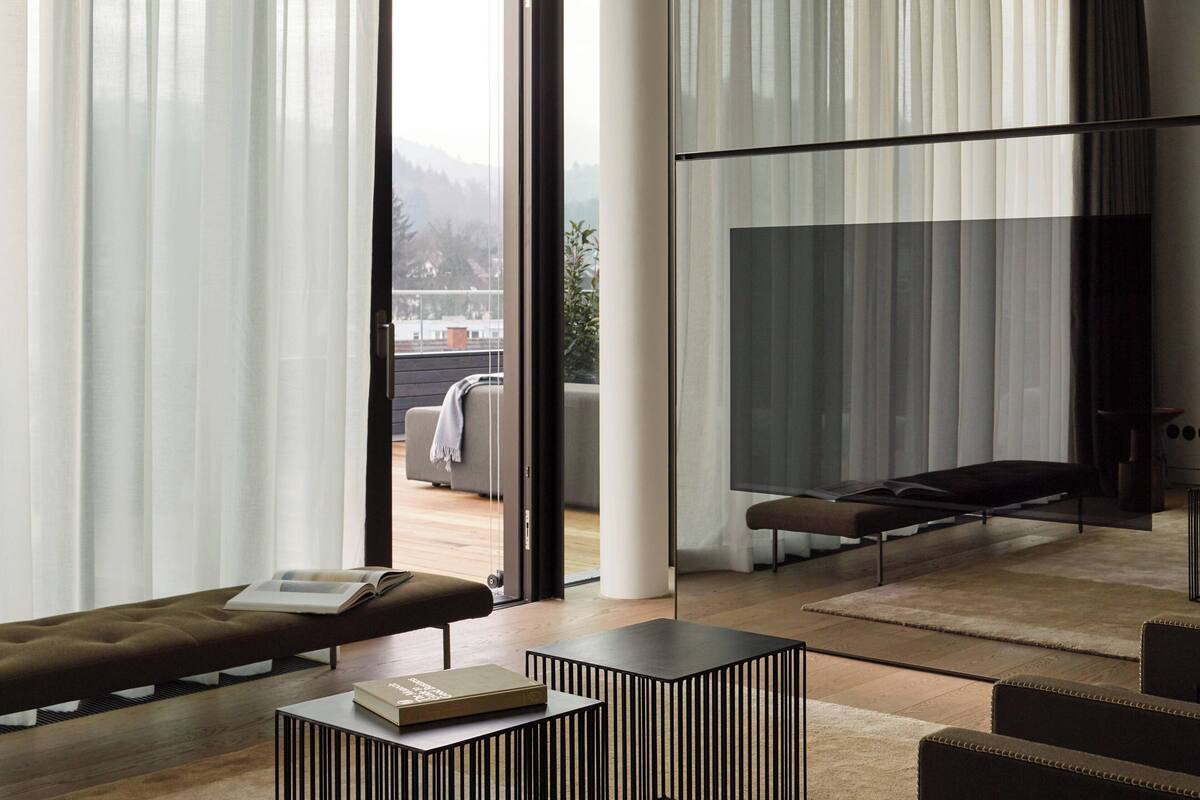 Un salon moderne avec un canapé, une table basse et une cloison en verre.