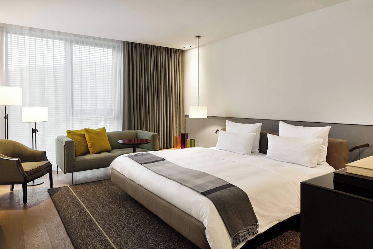 Une chambre d’hôtel avec un grand lit, un canapé, un bureau et une chaise.