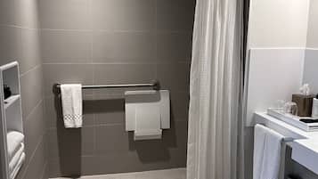 Un baño moderno con ducha, toallero, inodoro y lavabo.