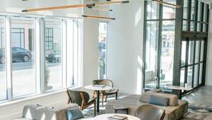Un interior moderno con zonas de estar, ventanas amplias y un suelo de diseño geométrico.