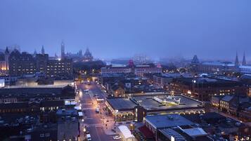 A cityscape at dusk with historic buildings and a river.